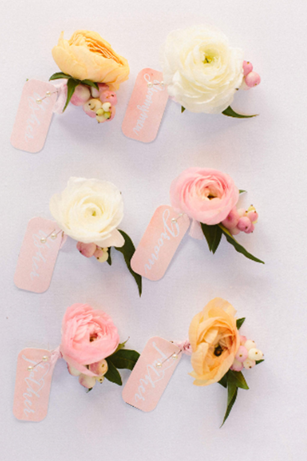 Coral ranunculus boutonnieres for groomsmen