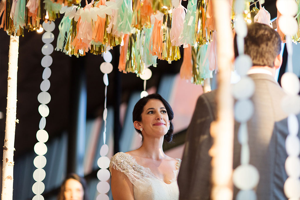 Sunset wedding ceremony under chuppah with paper tassels and garlands at Trinity River Audubon Center in Dallas