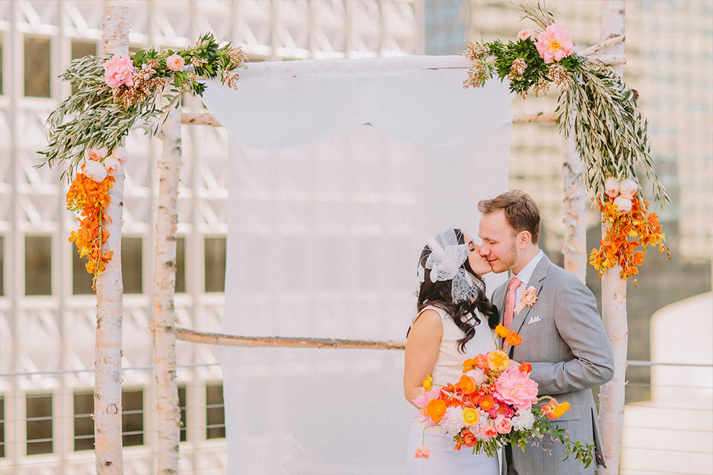 Bride and groom take a wedding day portrait on a rooftop outside in front of downtown Dallas buildings at The Venue at 400 North Ervay