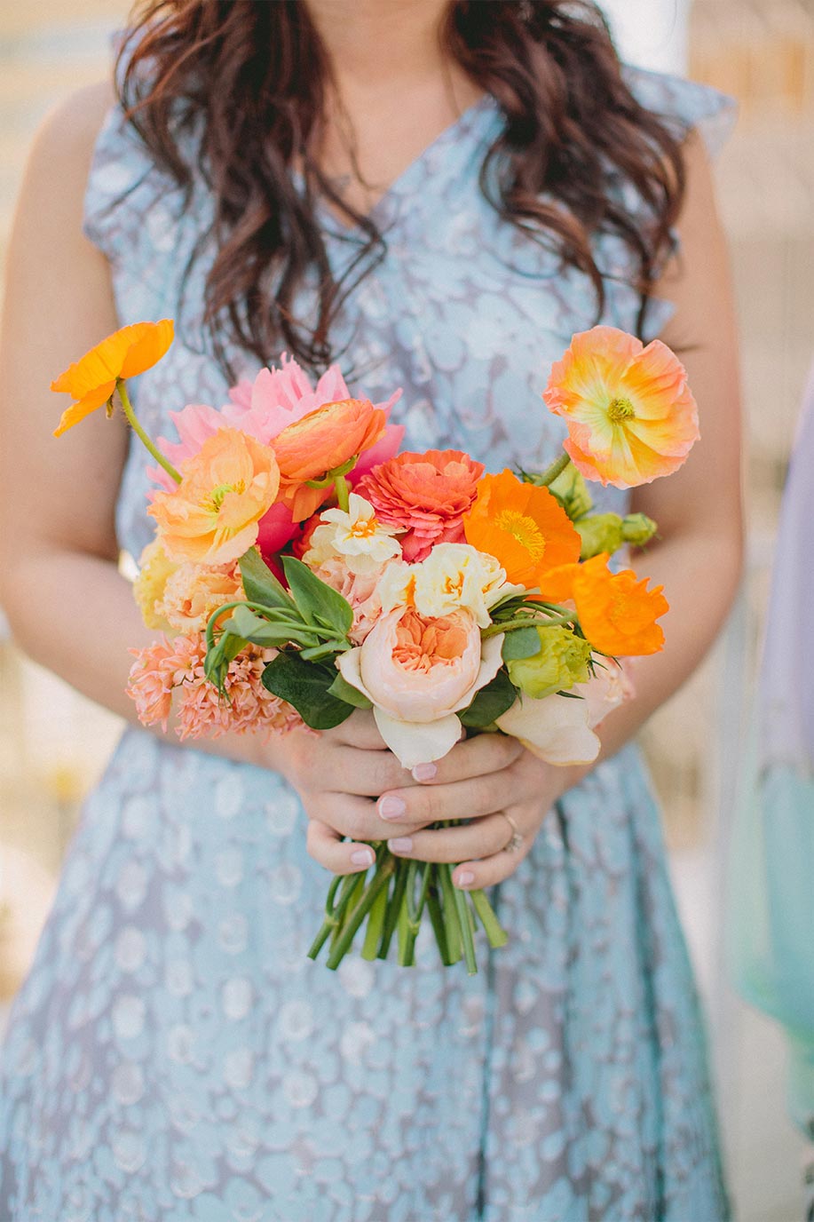 Bridesmaid with pink and orange bouquet and mix and match dress