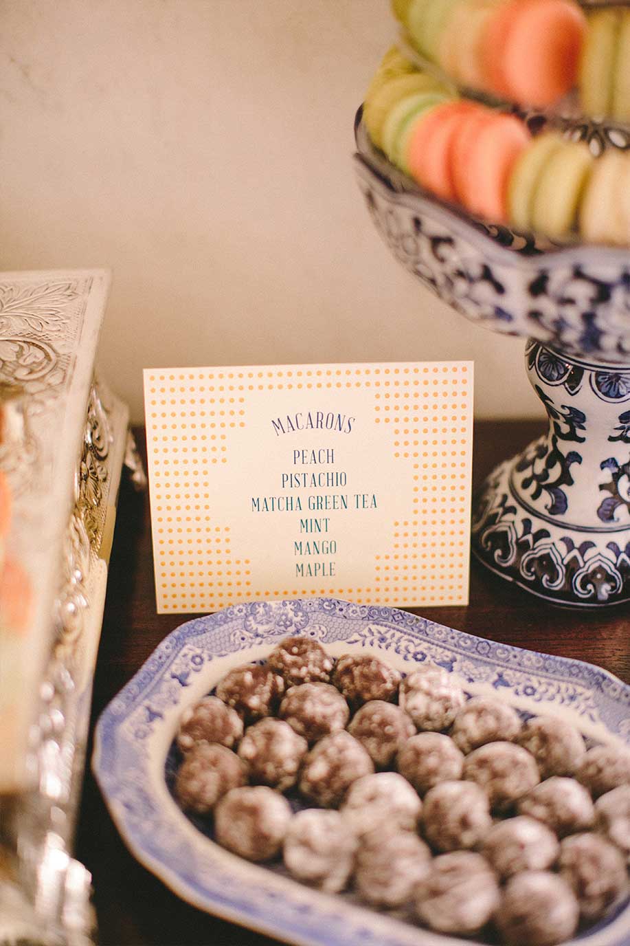 Wedding dessert table with macaroons and chocolate truffles on blue and white porcelain