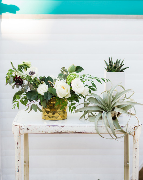 Air plant with green and white centerpiece and gold vase at The Belmont Hotel wedding reception