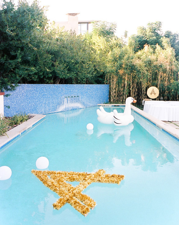 Inflatable swan and floating lights in pool used for wedding decor