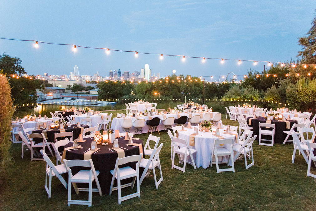 Tables and cafe lights at wedding reception at The Belmont Hotel overlooking downtown Dallas