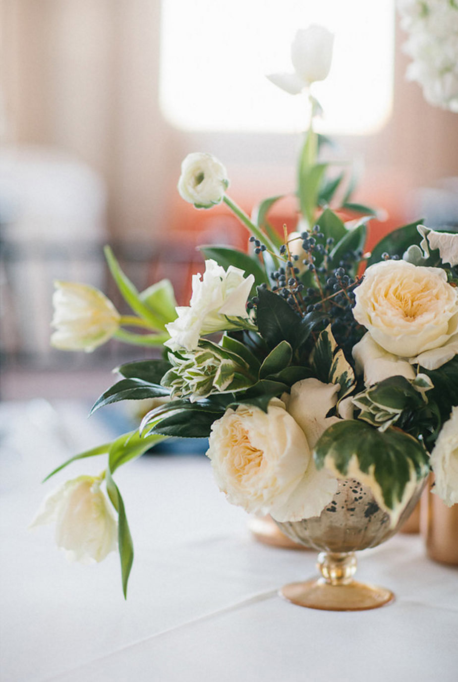 Gold footed bowl wedding centerpiece with greenery and white floral