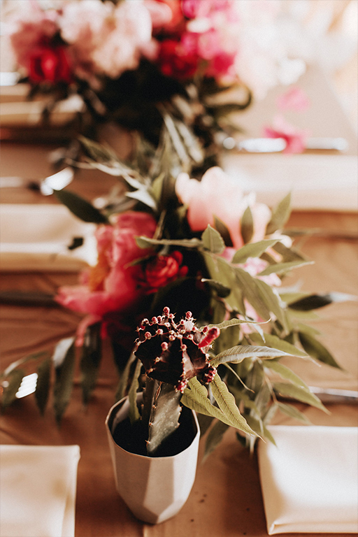 A collection of wedding reception centerpieces with geodes and concrete vessels