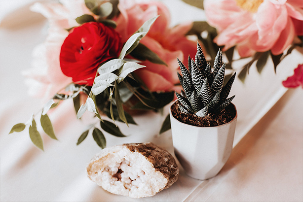 A concrete vessel with succulent at wedding reception table